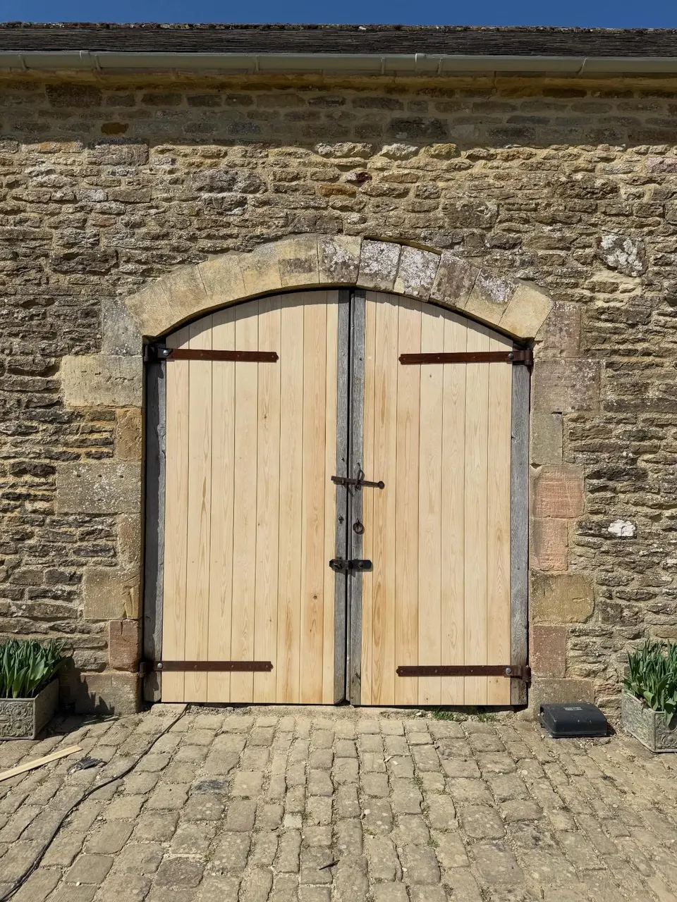 The arched barn doors after repair, with new v-jointed boarding, original iron bands and pins