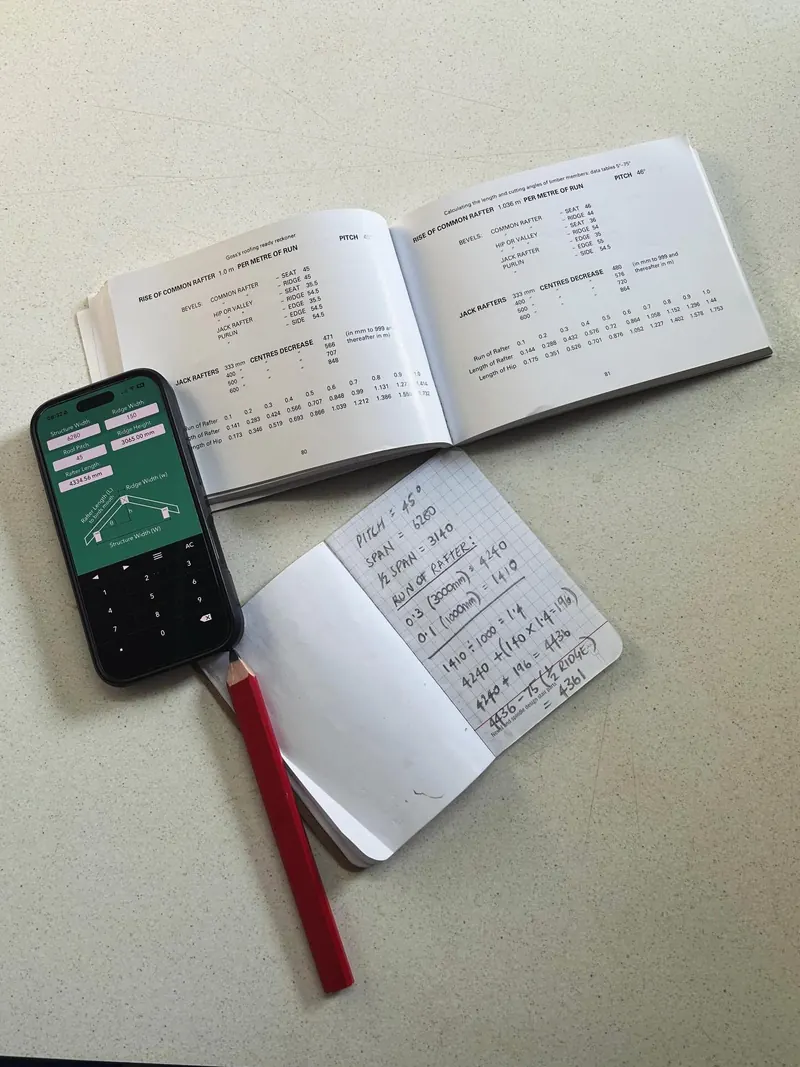 A rafter table book, notebook, calculator and carpenter's pencil on a worktop